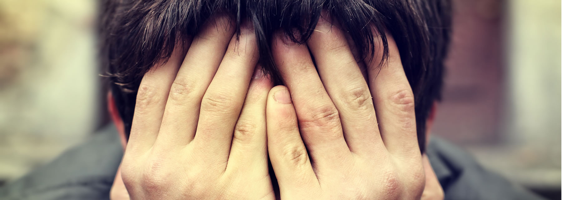 A person under debt stress with their head in their hands